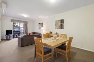 a dining room and living room with a table and chairs at 2BDR 1BTH 1PRK - Northbridge Magic in Perth
