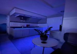 a room with a table and a kitchen with blue lights at Brooklyn Spring Getaway with Outdoor space in Brooklyn