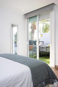 a bedroom with a bed and sliding glass doors at Sunnyland apartment ten-bel in Arona