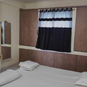 1 dormitorio con 2 camas y ventana en Kamala Shanti Palace, Jule, en Solapur
