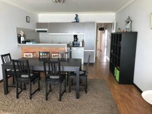 a kitchen and dining room with a black table and chairs at Appartement voor gezin in Middelkerke
