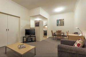 a living room with a couch and a table at Narnia in Northbridge - One Bedroom in Perth