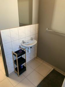 a bathroom with a sink and a mirror at Proventures Self-catering House in Ondangwa
