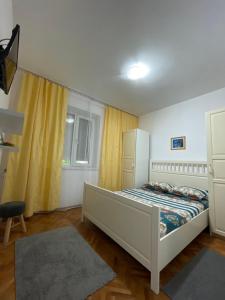 a bedroom with a bed and a yellow curtain at Apartament Nich in Mangalia