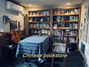 um quarto com uma mesa e uma estante de livros com livros em 云起山居庭院观景民宿 em Fenghuang