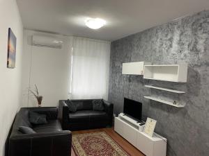 a living room with a couch and a tv at Apartament Nich in Mangalia