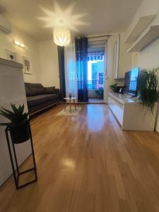 een lege woonkamer met een bank en een televisie bij Beach Pearl Apartment in Split +22 foto's