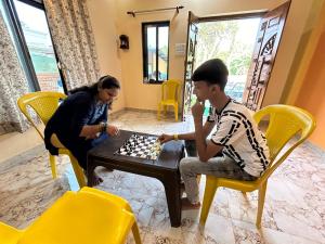 a woman and a boy playing a game of chess at Anand Heritage Villa in Nagaon