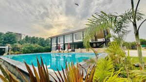 a house with a swimming pool in front of it at Vintclub Resort in Lucknow