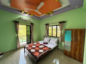 a bedroom with a bed with a ceiling fan at Anand Heritage Villa in Nagaon