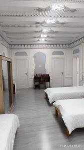 a room with four beds and a table in it at Bibikhanum Hotel in Samarkand
