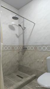 um chuveiro com uma porta de vidro na casa de banho em Bibikhanum Hotel em Samarkand