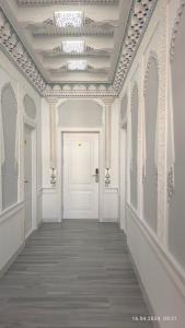 a hallway with a white door and a ceiling at Bibikhanum Hotel in Samarkand