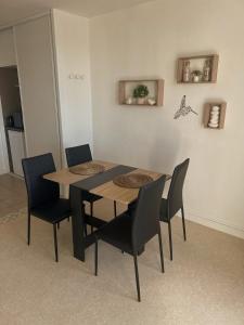 a dining room table and chairs in a room at Studio vue sur mer avec véranda - Roscoff in Roscoff