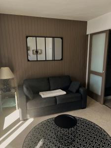a living room with a couch and a table at Studio vue sur mer avec véranda - Roscoff in Roscoff