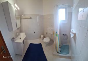 un bagno bianco con lavandino e WC di Gregory-Vassilis Apartments a Dassia