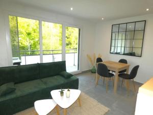 ein Wohnzimmer mit einem grünen Sofa und einem Tisch in der Unterkunft Flat 4 people St Julien NEAR GENEVA in Saint-Julien-en-Genevois