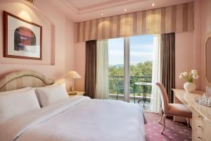 a bedroom with a bed and a desk and a window at Hotel Panorama in Thessaloniki