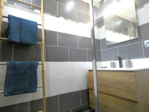 y baño con lavabo, espejo y toallas azules. en Flat 4 people St Julien NEAR GENEVA, en Saint-Julien-en-Genevois