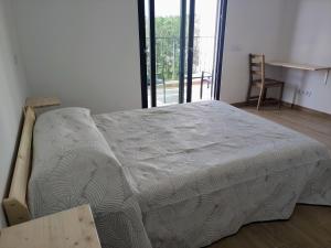 a large bed in a room with a window at Casa do Belé in Faro
