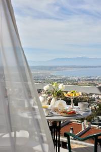 une table avec des assiettes de nourriture sur un balcon dans l'établissement Hotel Panorama, à Thessalonique