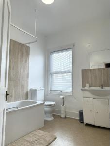 een badkamer met een bad, een toilet en een wastafel bij BEST PRICE! - Newly Refurbished - Seaside Terrace House- 7 Guests in Portsmouth