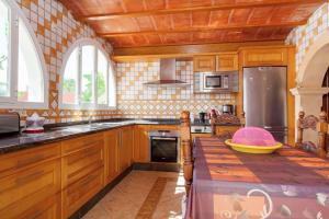 a kitchen with wooden cabinets and a counter top at Can Ramos in Ses Fontanelles