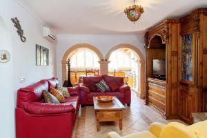 a living room with a red couch and a table at Can Ramos in Ses Fontanelles