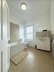 een badkamer met een bad, een toilet en een wastafel bij BEST PRICE! - Newly Refurbished - Seaside Terrace House- 7 Guests in Portsmouth