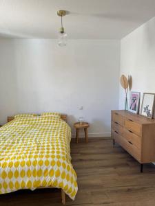 a bedroom with a yellow bed and a wooden dresser at Appartement centre historique in Narbonne +4 photos