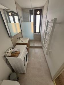 a bathroom with a sink and a washing machine at Appartement centre historique in Narbonne