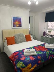 - une chambre avec un grand lit et des serviettes dans l'établissement Babbacombe Palms, à Torquay