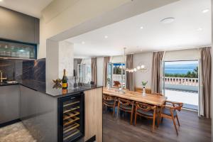 a kitchen and dining room with a table and chairs at New Luxury Beach Villa in Duće