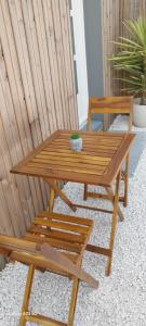 een houten picknicktafel en bank met een plant erop bij Chez Lyly et Juju in Angers