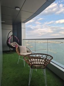 einen Balkon mit einem Tisch und Stühlen sowie Aussicht in der Unterkunft Luxury Romantic Sea View Apartment. in Manama
