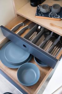 a drawer in a kitchen with plates and utensils at Thornfield Farm Luxury Glamping Pods, The Dark Hedges, Ballycastle in Stranocum
