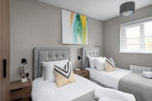 two beds in a bedroom with white walls at City Stay Apartments - Geldonia Court Bedford in Bedford