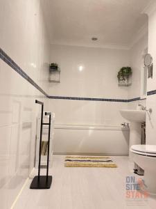 a white bathroom with a tub and a sink at On Site Stays - Cosy ground floor 2 bed with Wifi and lots of Parking in Colchester