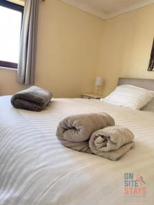 um quarto com duas toalhas numa cama em On Site Stays - Cosy ground floor 2 bed with Wifi and lots of Parking em Colchester