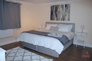 a bedroom with a large bed with two towels on it at On Site Stays - Cosy ground floor 2 bed with Wifi and lots of Parking in Colchester