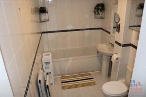 a bathroom with a tub and a toilet and a sink at On Site Stays - Cosy ground floor 2 bed with Wifi and lots of Parking in Colchester