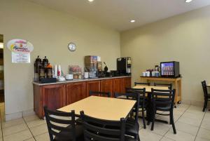 a restaurant with tables and chairs and a counter at Super 8 by Wyndham Roseburg in Roseburg