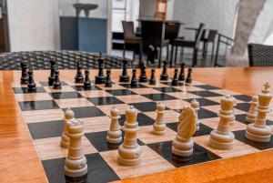 Wyndham San Jose Herradura في سان خوسيه: لوحة شطرنج مع قطع شطرنج على طاولة خشبية
