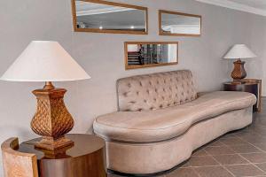 a couch in a living room with a lamp at Wyndham San Jose Herradura in San José