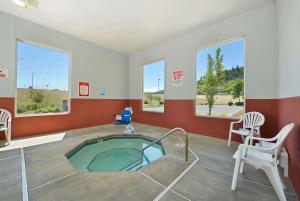 a room with a swimming pool with a chair and a table at Super 8 by Wyndham Roseburg in Roseburg