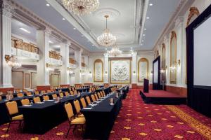 Cette grande chambre comprend des rangées de tables et de chaises. dans l'établissement The New Yorker, A Wyndham Hotel, à New York