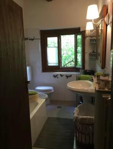 a bathroom with a sink and a toilet and a window at Lago di Como - home holiday in Zelbio