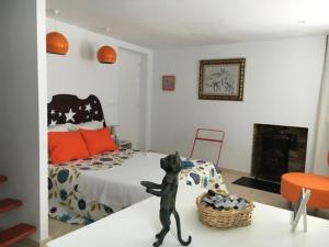 a toy cat statue in a bedroom with a bed at DUNØ Suites in Dun-le-Palestel