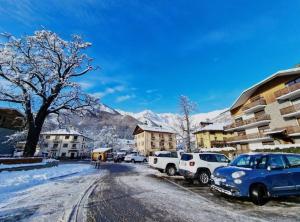een met sneeuw bedekte straat met auto's geparkeerd voor gebouwen bij Appartamento a Bardonecchia in Bardonecchia