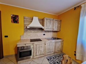 een keuken met houten kasten en een witte kap bij Appartamento a Bardonecchia in Bardonecchia